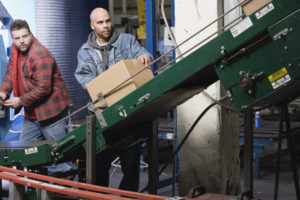 Two men operating conveyor belt