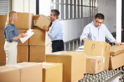 Workers Checking Goods On Belt In Distribution Warehouse